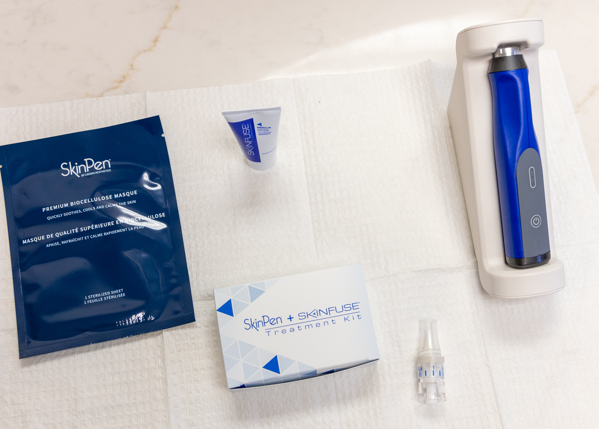 The complete SkinPen treatment utility kit, used in anti-aging in Southlake treatments. The special handheld device sits alongside the treatment infusing kit, a post-treatment mask, and the topical numbing cream used before the session.