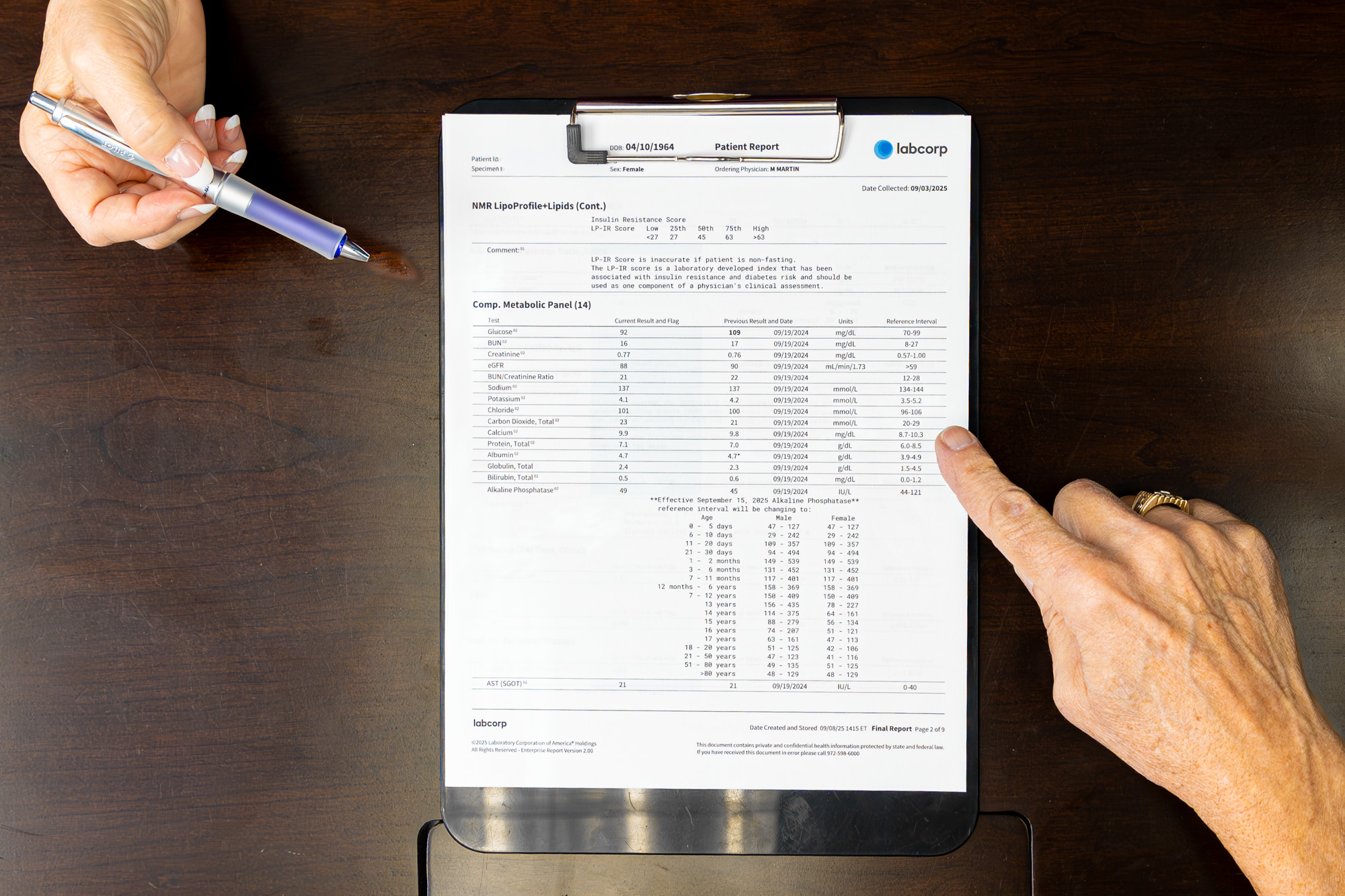 A longevity doctor in Southlake at DLHC reviews a patient's lab results with him. We see their hands; the provider pointing to a part of the lab sheet with a pen as they review the information together.